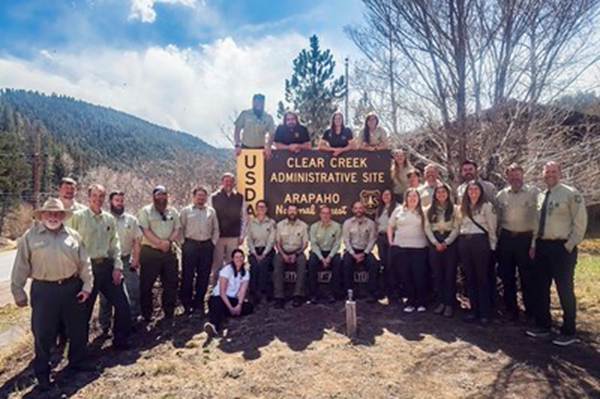 A group of people posing for a photo with a sign
AI-generated content may be incorrect.